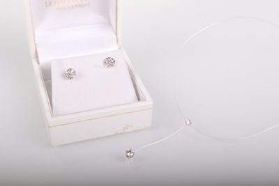 une boîte blanche contenant une paire de boucles d'oreilles en argent