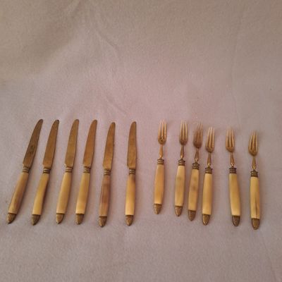 six fourchettes et un couteau sont alignés sur une table