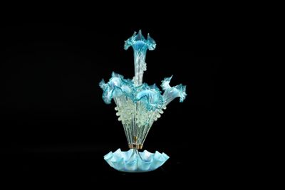 a glass vase with a blue flower inside of it