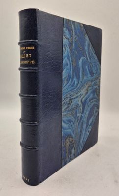 un vieux livre à la couverture bleue posé sur une table blanche