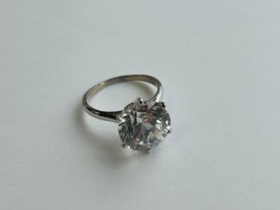gros plan d'une bague en diamant sur une surface blanche