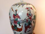 un vase orné d'une peinture, posé sur un socle en bois