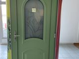 a green door with a picture on it in the middle of a room