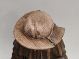 a wooden statue of a man with a hat and a cane
