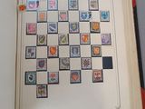 an open book with stamps on it on a table