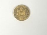 a close up of a gold coin on a white surface