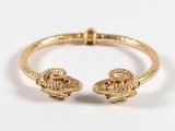 un gros plan sur un bracelet en or orné de deux serpents