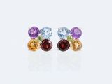 une paire de boucles d'oreilles en pierres multicolores et en argent posées sur un fond blanc