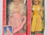 deux poupées dans leur boîte représentant une petite fille en robe jaune, une petite fille en robe rose et une petite fille en robe jaune