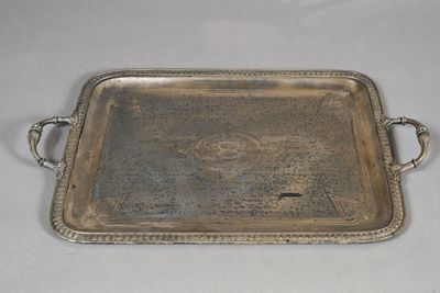an antique silver tray with handles and handles on a table