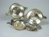 silver plated dishes and spoons on a white surface