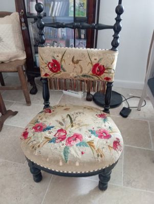 a chair that has a floral seat on it in a living room