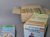 many children ' s books in a box on the table