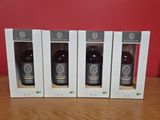 trois bouteilles de vin dans des cartons posées sur une table