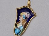 un pendentif plaqué or représentant une femme en robe bleue