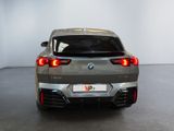 the rear end of a silver bmw suv parked in a room