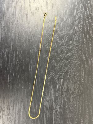 a gold plated bookmark with a long chain hanging from it