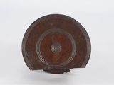an old wooden plate with a circular design on it