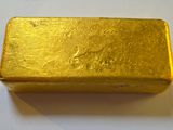 a gold bar sitting on a white surface
