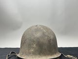 an old helmet is sitting on top of a black cloth