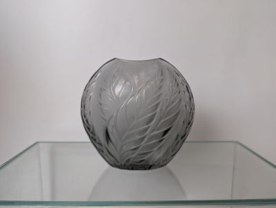 a glass table with a glass vase on top of it