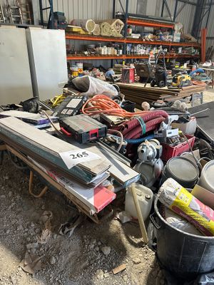 un tas de bric-à-brac dans un entrepôt, avec un réfrigérateur et d'autres objets