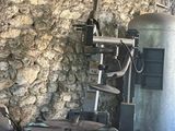 une machine qui se trouve dans une pièce, avec un mur de pierre derrière elle
