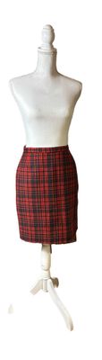 mannequin with red and black checkered skirt on a white mannequin stand