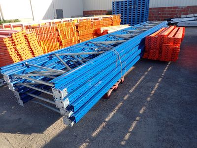 a pile of blue and orange steel beams in a warehouse