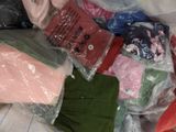 a pile of clothing that is sitting on a bed
