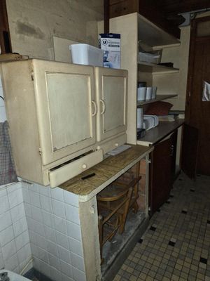un vieux réfrigérateur au milieu d'une cuisine sale