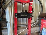 a picture of a red hydraulic press in a garage