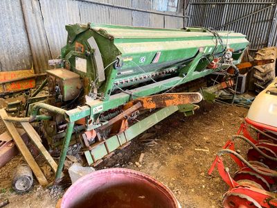 une grosse machine verte qui est garée dans la poussière