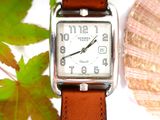a watch that is sitting on a table next to a leaf
