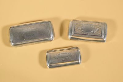 trois porte-savons en métal argenté posés sur une surface jaune