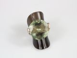 an image of a ring with a green stone on top of a wooden stand