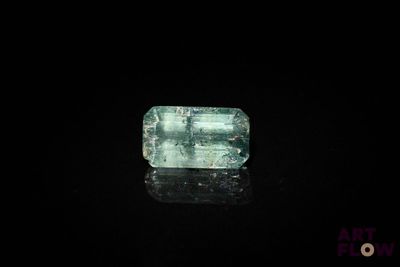un gros plan d'une émeraude verte sur une surface noire