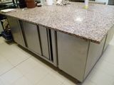 a kitchen island with a granite counter top in the middle of the room