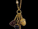a close up of a gold plated necklace with various charms