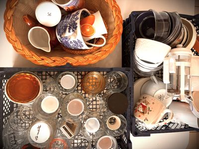 a basket full of dishes and cups on a table