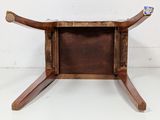 a small wooden table with a glass holder on top of it