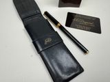 black leather case with a pen and business card next to it