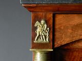 a wooden cabinet with a brass decoration on the top