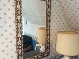 a table with a lamp and a mirror in a room