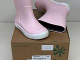 une paire de bottes de pluie roses posée sur une boîte en carton