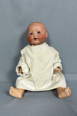 une image représentant une poupée assise sur une surface grise