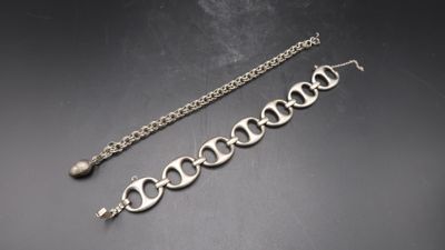 a close up of a bracelet and a chain on a table