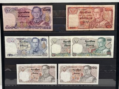 Quatre billets de banque différents sont exposés dans une vitrine.