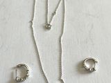 gros plan d'un collier et de boucles d'oreilles sur une surface blanche