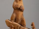 a wooden sculpture of a bear and a squirrel on a log